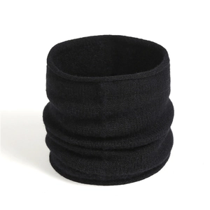 Detail view of black knitted neck warmer with soft pleated texture and ribbed design