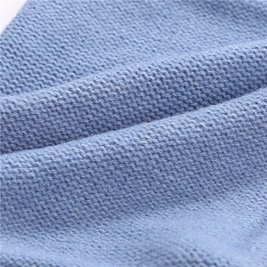 Detailed close-up of soft light blue knit fabric texture with fine fuzzy wool finish
