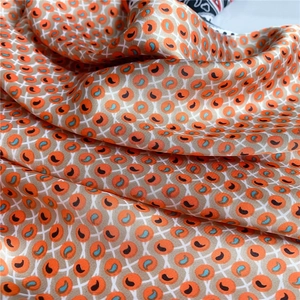 Vue macro détaillée de la texture soyeuse paisley et des motifs géométriques du foulard