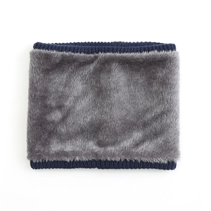 Detail von grauem Plüsch-Futter und blauem Stricksaum eines warmen Winter-Schlauchschals