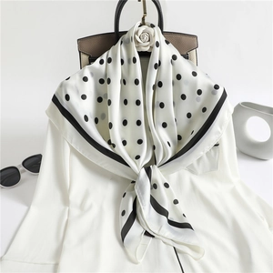 French style white silk scarf with black polka dots tied elegantly on a white shirt