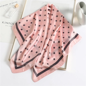 Pink polka dot silk square scarf 90cm with black border shown in elegant lifestyle setting