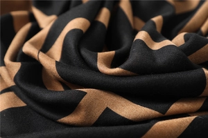 Detailaufnahme von Baumwoll-Leinen-Schal mit schwarz-braunem Zickzackmuster und Knitteroptik