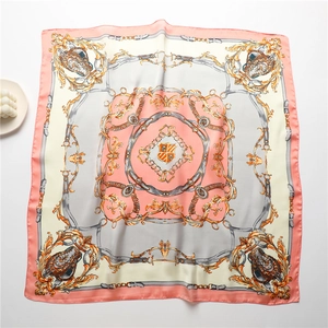 Vue à plat d'un foulard en soie de 70 cm avec motifs baroques et bord rose