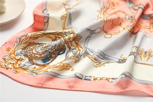 Gros plan du foulard en soie avec motifs de chaînes baroques et drapé élégant