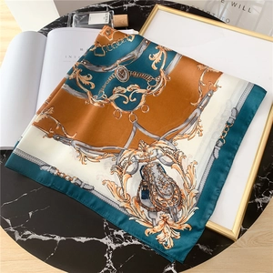 Élégant foulard en soie de 70 cm de style vintage avec chaînes et lanières sur une table