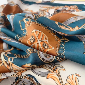 Détail de l'imprimé baroque à chaînes sur un foulard en soie aux motifs vert et orange