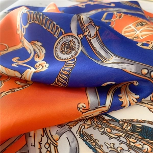 Détail macro des motifs de chaînes baroques et texture soyeuse d'un foulard carré