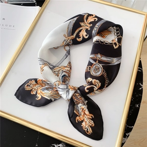 Détail du motif de chaîne baroque sur un carré de soie de haute qualité aux tons dorés