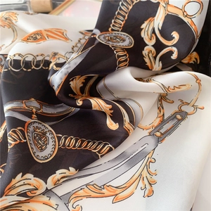 Macro de l'écharpe en soie avec motif de chaîne, blason et détails de texture baroque