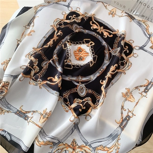 Détail macro d'un foulard carré en soie avec imprimés de chaînes baroques et dorures