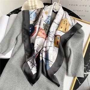 Détail d'un foulard en soie à motif maison abstrait drapé sur une maille grise