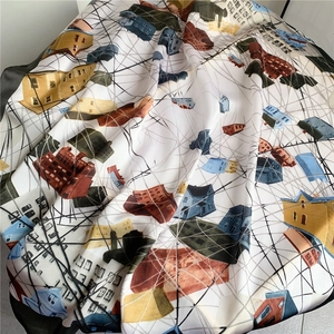 Détail d'un foulard en satin avec imprimés d'architecture abstraite et texture soyeuse