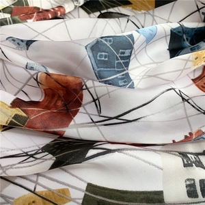 Gros plan sur l'imprimé artistique et la texture douce de ce foulard en soie de 70 cm