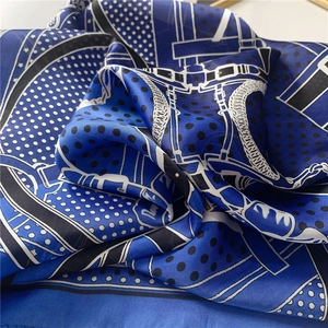 Gros plan d'un foulard en soie bleu roi avec pois et motifs équestres chics