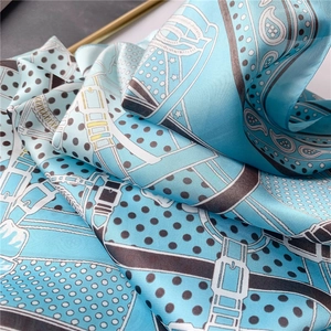 Gros plan d'un foulard en soie bleu clair avec pois et motifs de boucles