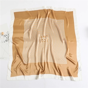 Détail macro du foulard en soie camel avec motif à rayures et texture satinée lisse