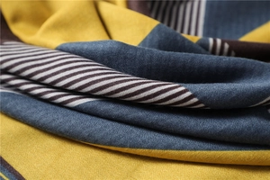Close-up of geometric striped scarf showing mustard and navy color-blocked fabric detail