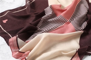 Detail of soft multi-color geometric striped scarf with heart pattern and fine texture