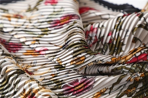 Detailed view of accordion pleated fabric with vintage floral print on a silk scarf