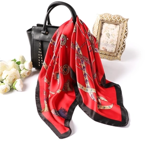 Élégant foulard rouge 70x70cm motif chaîne dorée drapé sur un sac à main en cuir noir