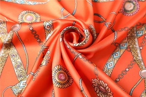 Vue détaillée du foulard en soie orange avec motifs de chaînes vintage et de gemmes