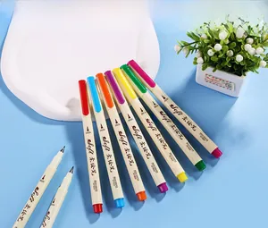 Set of seven colorful soft brush pens in muted tones displayed on a light blue background