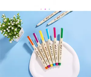 Detailed view of eight colorful soft brush sign pens arranged neatly in a decorative tray