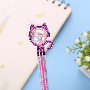 Close-up of a purple cat-shaped pen topper with a faceted crystal and pink stone filling