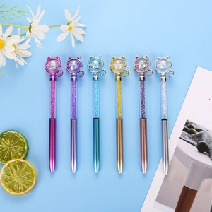 Creative cat head ballpoint pens with glitter crystals on a light blue background
