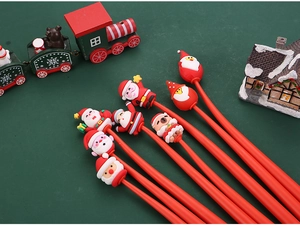 Close-up of 7 Christmas cartoon pens featuring Santa and reindeer on a festive backdrop