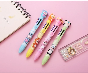Détail des personnages d'animaux 3D et des boutons multicolores sur les stylos à bille