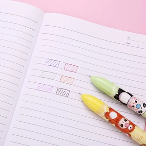 Stylos à bille multicolores animaux de dessin animé sur cahier, couleurs vert et jaune