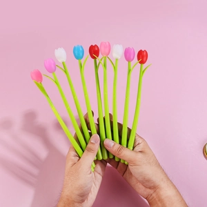Close-up of hand holding colorful tulip-shaped pens in pink, white, blue and red colors