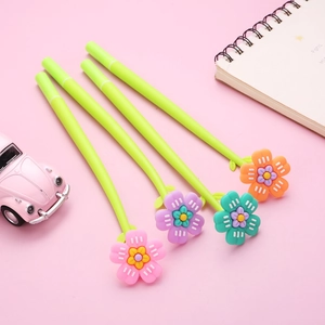 Close-up of four colorful flower-shaped gel pens with green curved bodies on a pink background