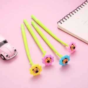Detail of four creative floral gel pens with cartoon bear icons on a soft pink desk
