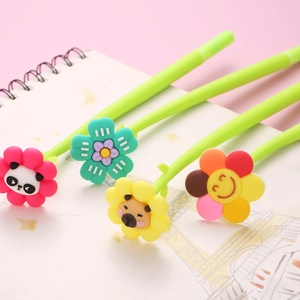Detailed view of four colorful flower pens with silicone toppers on a spiral notebook
