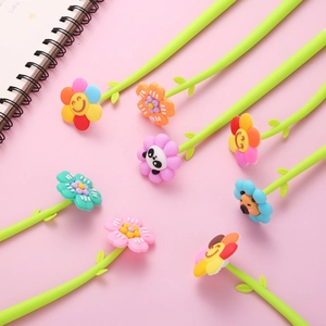 Cute green flower-themed gel pens with cartoon floral toppers on a pink desk background