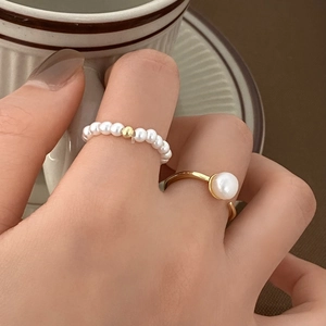 Minimalist freshwater pearl gold ring set shown in a stylish lifestyle hand setting