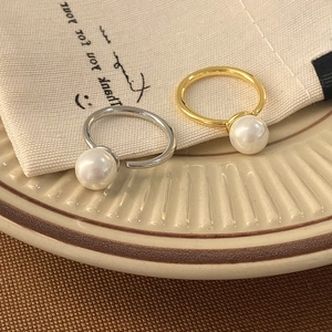 Elegant two-piece pearl ring set in gold and silver finish on a stylish ceramic tray