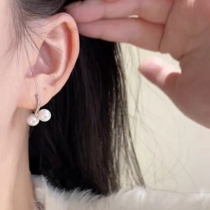 Orecchini vintage a doppia perla con ganci in argento indossati da una modella