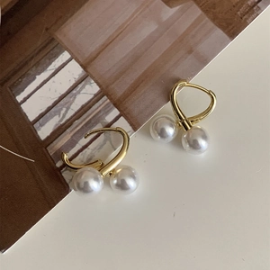 Orecchini vintage francesi incrociati in oro con perle su sfondo estetico