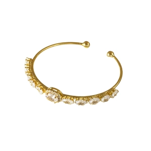 Elegante bracciale rigido dorato regolabile con zirconi brillanti e gemma centrale halo