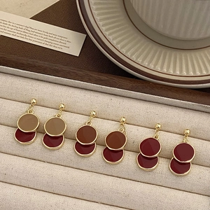 Détail de boucles d'oreilles vintage à double disque avec bordure dorée et émail