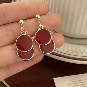 Gros plan détaillé de boucles d'oreilles rondes en émail rouge avec bordures dorées