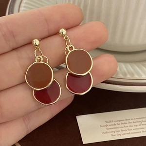 Vue détaillée des boucles d'oreilles vintage à disques superposés marron et bordeaux polis
