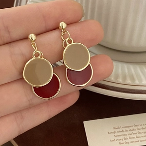 Vue détaillée des boucles d'oreilles émaillées kaki et bordeaux en métal doré rétro