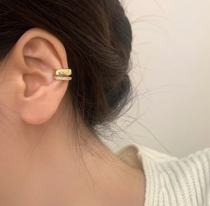 Detail of double-layer gold ear cuff featuring micro-pave zircons and textured wavy metal