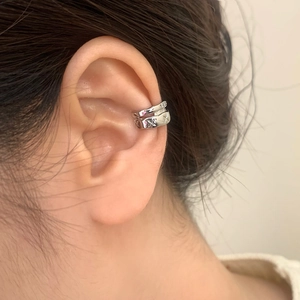 Silver ear cuff set with micro-inlaid zircons and cross pattern on a neutral background