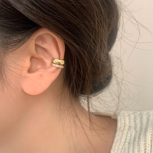 Close-up of gold double-layer ear cuff with quilted texture and pavé zircon stones